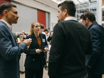 Vier Teilnehmende im angeregten Gespräch, im Hintergrund Teile des Mittagsbuffets