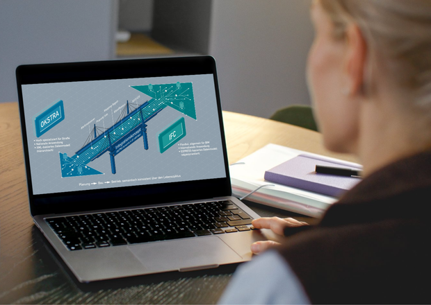 Eine Person sitzt an einem Laptop und betrachtet eine technische Grafik zur Verbindung der Datenformate OKSTRA und IFC. Auf dem Bildschirm ist ein Brückenmodell mit schematischen Datenflüssen und Hinweisen zum Integrationskonzept zu sehen.