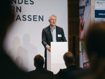 Moderator Klaus Lintemeier steht hinter dem Moderationspult