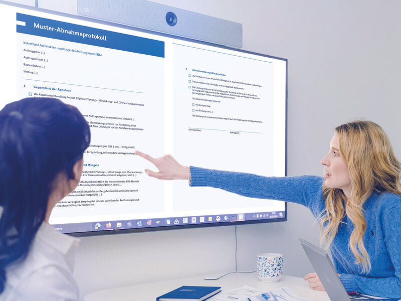 Drei Personen blicken auf einen Großbildschirm mit der Darstellung des Muster-Abnahmeprotokolls