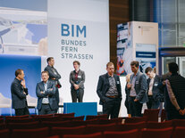 Mehrere Panelteilnehmer im Austausch miteinander, im Hintergrund Leinwand mit Aufdruck BIM Bundesfernstrassen
