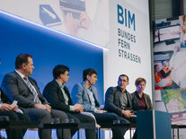 Aufnahme von fünf Podiumsdiskutanten, die ihren Kopf in Richtung des Sprechers gedreht haben