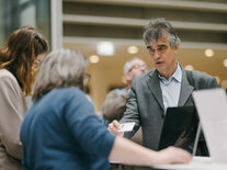 Teilnehmer des Fachsymposiums wird von den Mitarbeiterinnen am Check-in Counter begrüßt