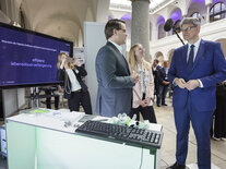 Der Bundesverkehrsminister und ein Teilnehmer des Dialogmarkts diskutieren zu den Vorteilen des Digitalen Zwillings