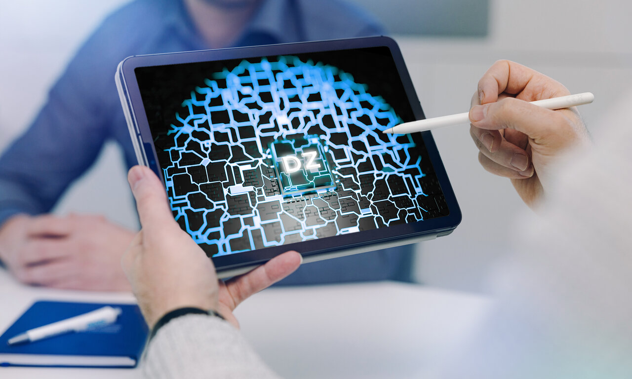 Ein Mensch hält einen Tablet-Computer mit der Abbildung eines virtuellen Startknopfes für den Digitalen Zwilling in der einen Hand und macht sich bereit, diesen zu betätigen. 