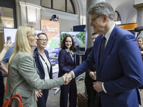 Bundesverkehrsminister Patrick Schnieder begrüßt eine Teilnehmerin des Dialogmarkts