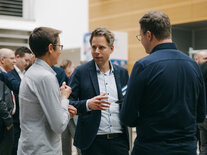 Angeregtes Gespräch unter drei Teilnehmenden des Fachsymposiums